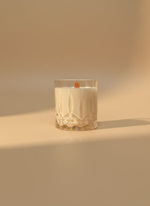 Glass candle with a wooden wick on a warm background