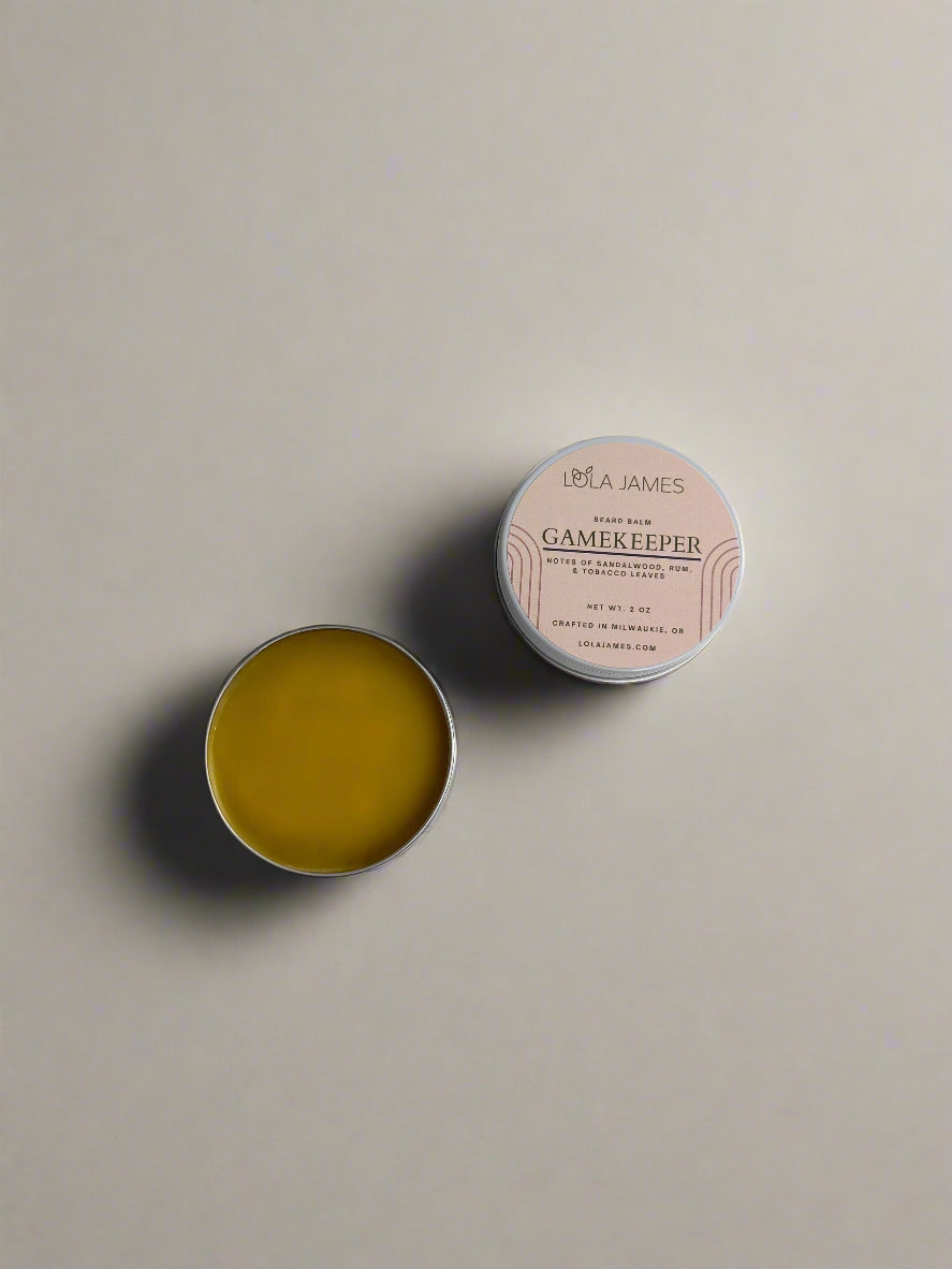 2 tins of beard balm on a beige background.