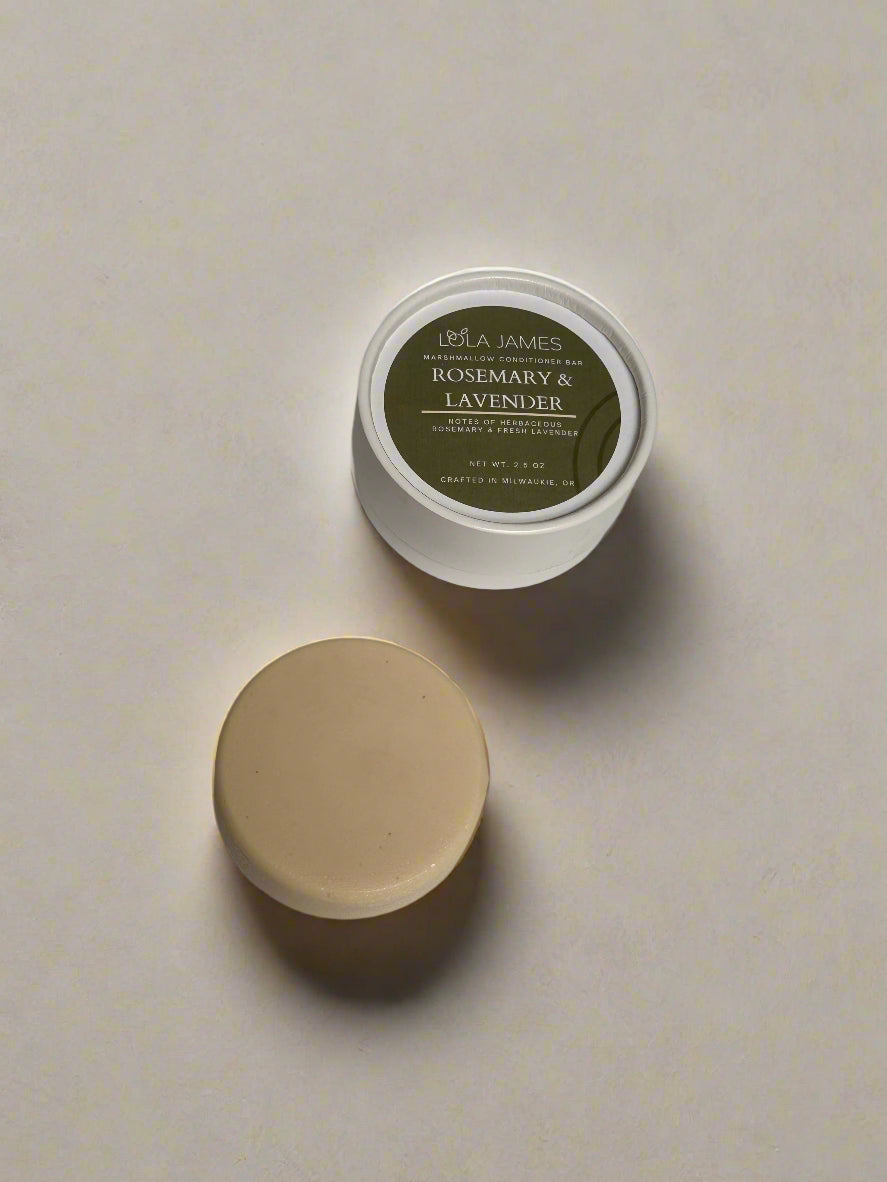 Conditioner bar next to white and green paper tube packaging with neutral background.
