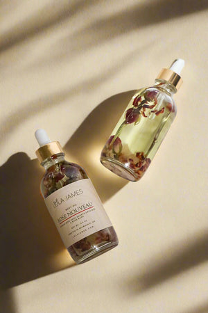 Two glass bottles with floral elements on a beige background