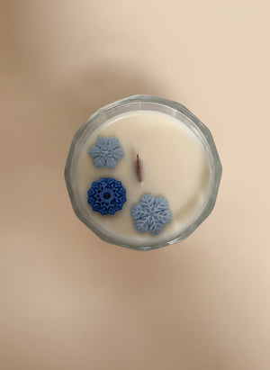 Candle with decorative elements on a beige background