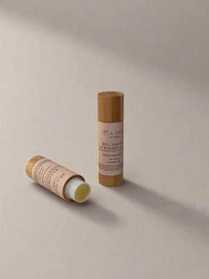 Two bamboo-themed lip balm tubes on a light beige background
