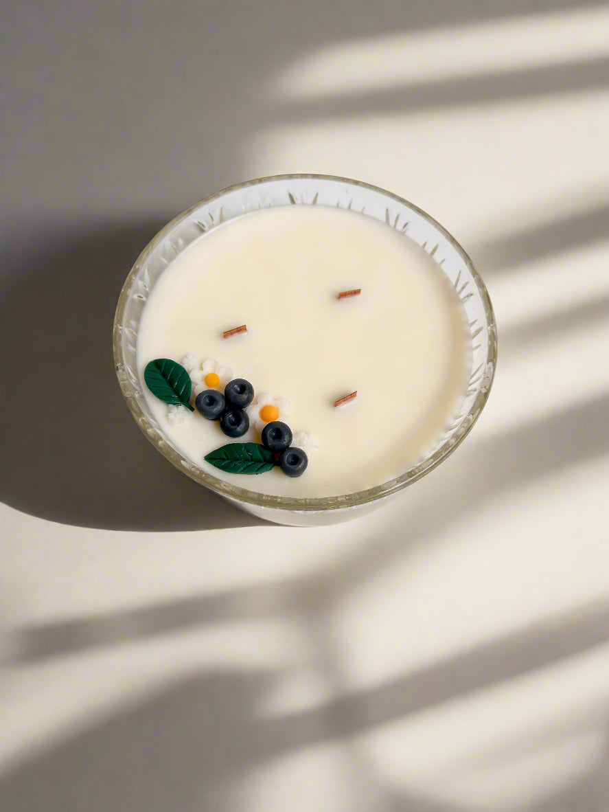 Soy candle in a vintage vessel with wooden wicks and black currant, leaf, and flower embeds.