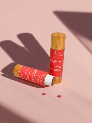 2 Lip balms, bamboo container, shadows and pink background.