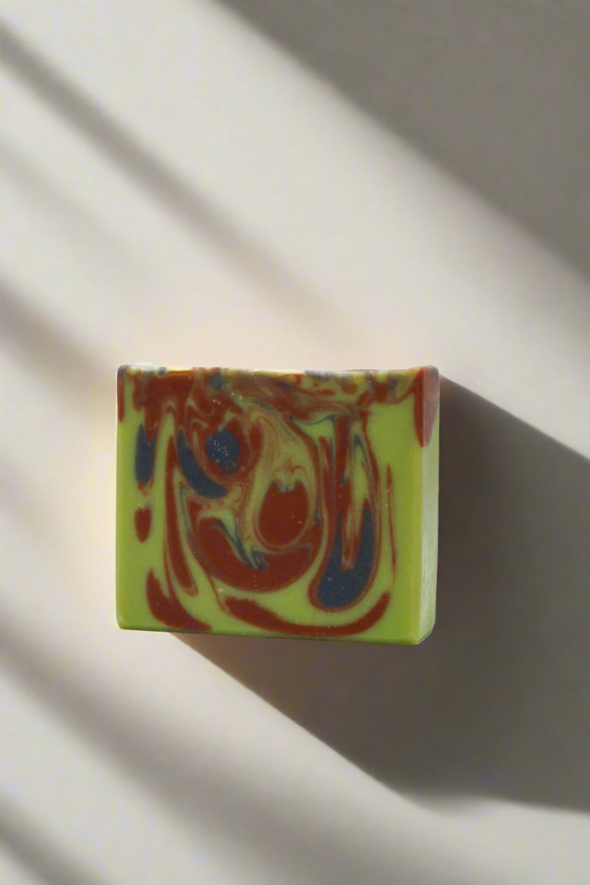 Marbled soap bar with red, blue, and green colors on a white background