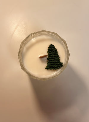 Candle with tree decoration on a neutral background