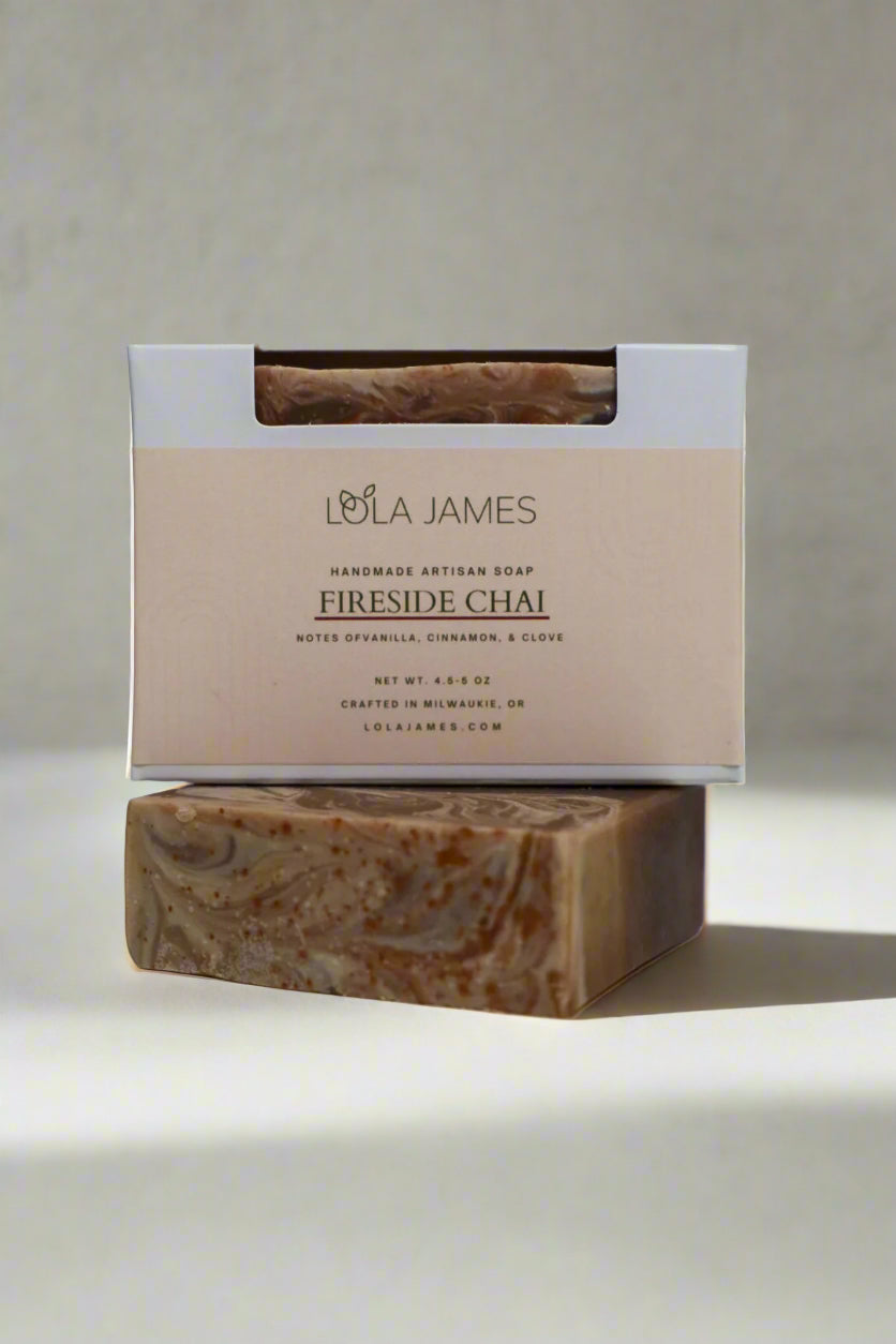 Brown and cream swirled soap stacked in packaging, gray background.