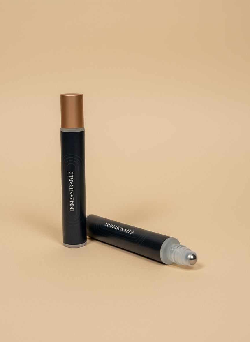 Two rollerballs with black labels branding on a tan background