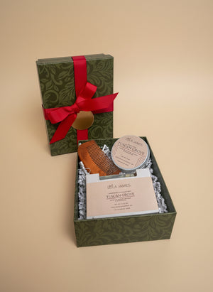 Gift set with comb, beard balm, and soap in a decorative box with a red ribbon on a white background.