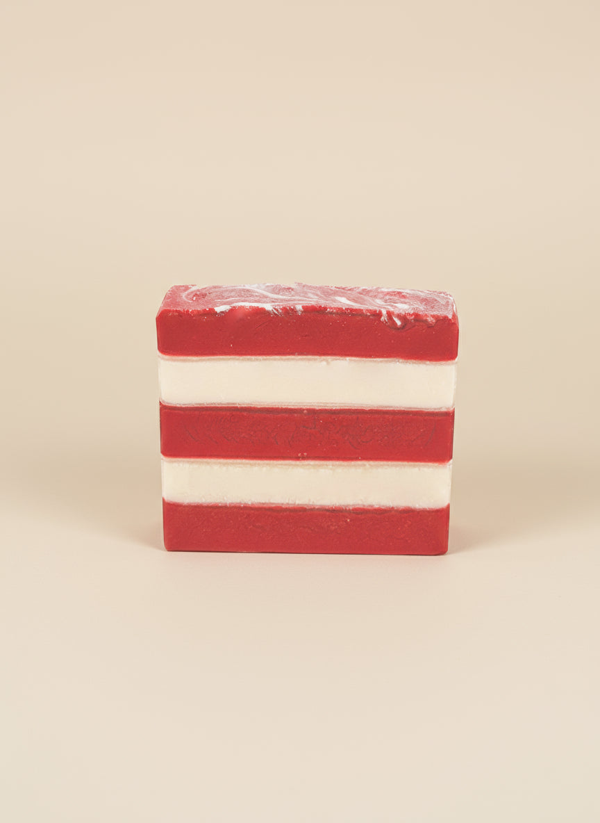 Red and white striped bar of soap on a beige background