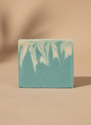 Blue and white soap bar on a tan background.