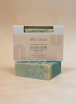 Lola James Lucky Star soap bar with packaging on a tan background