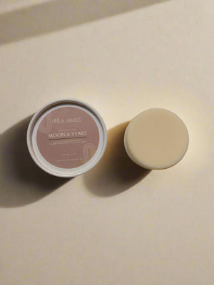 Body Butter Bar sitting next to paperboard packaging with a beige background.