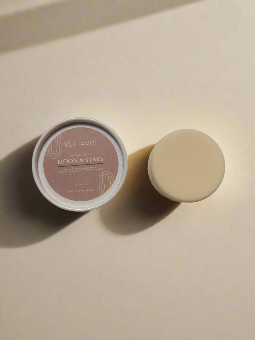 Body Butter Bar sitting next to paperboard packaging with a beige background.