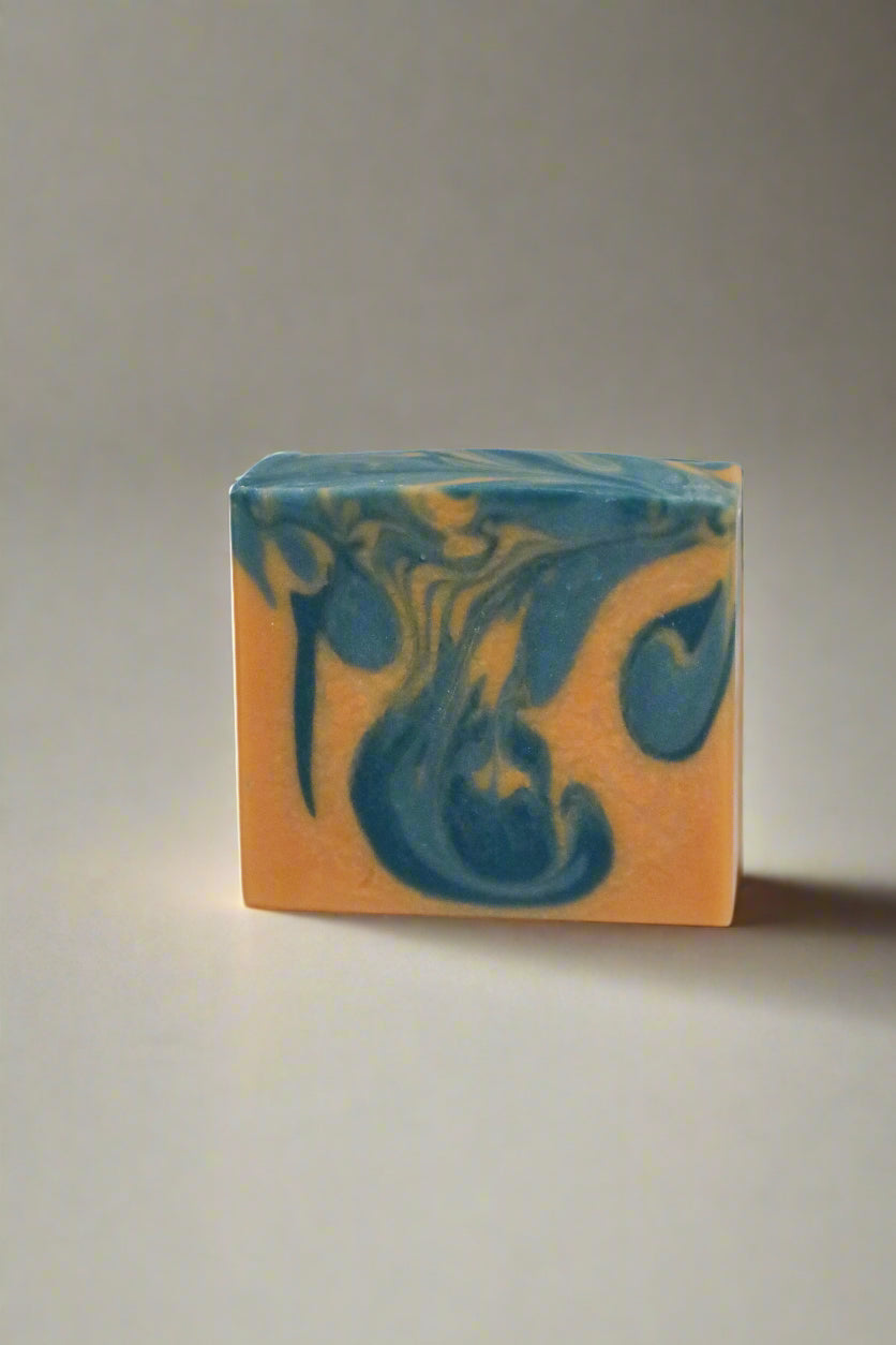 Marbled bar of soap with blue and sandy yellow colors on a neutral background
