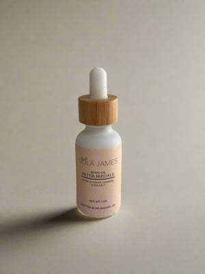 White bottle of Lola James' beard oil with a bamboo lid on a tan background.