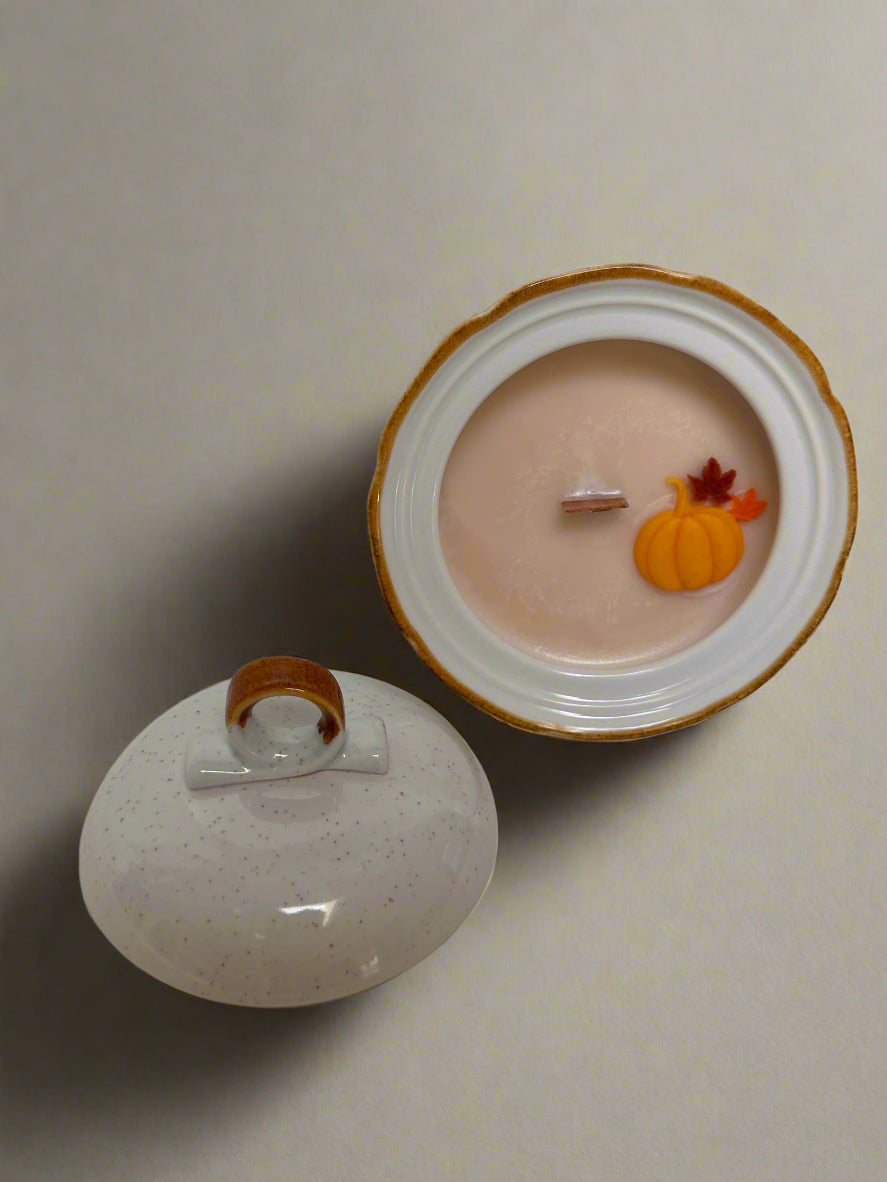 Candle with wooden wick and pumpkin and leaf embeds. In a vintage stoneware sugar bowl with brown accents. 