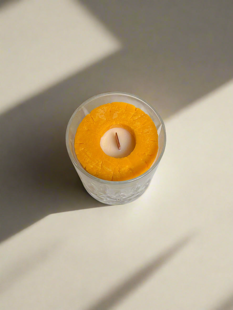 Pineapple ring embed with wooden wick in a crystal glass.
